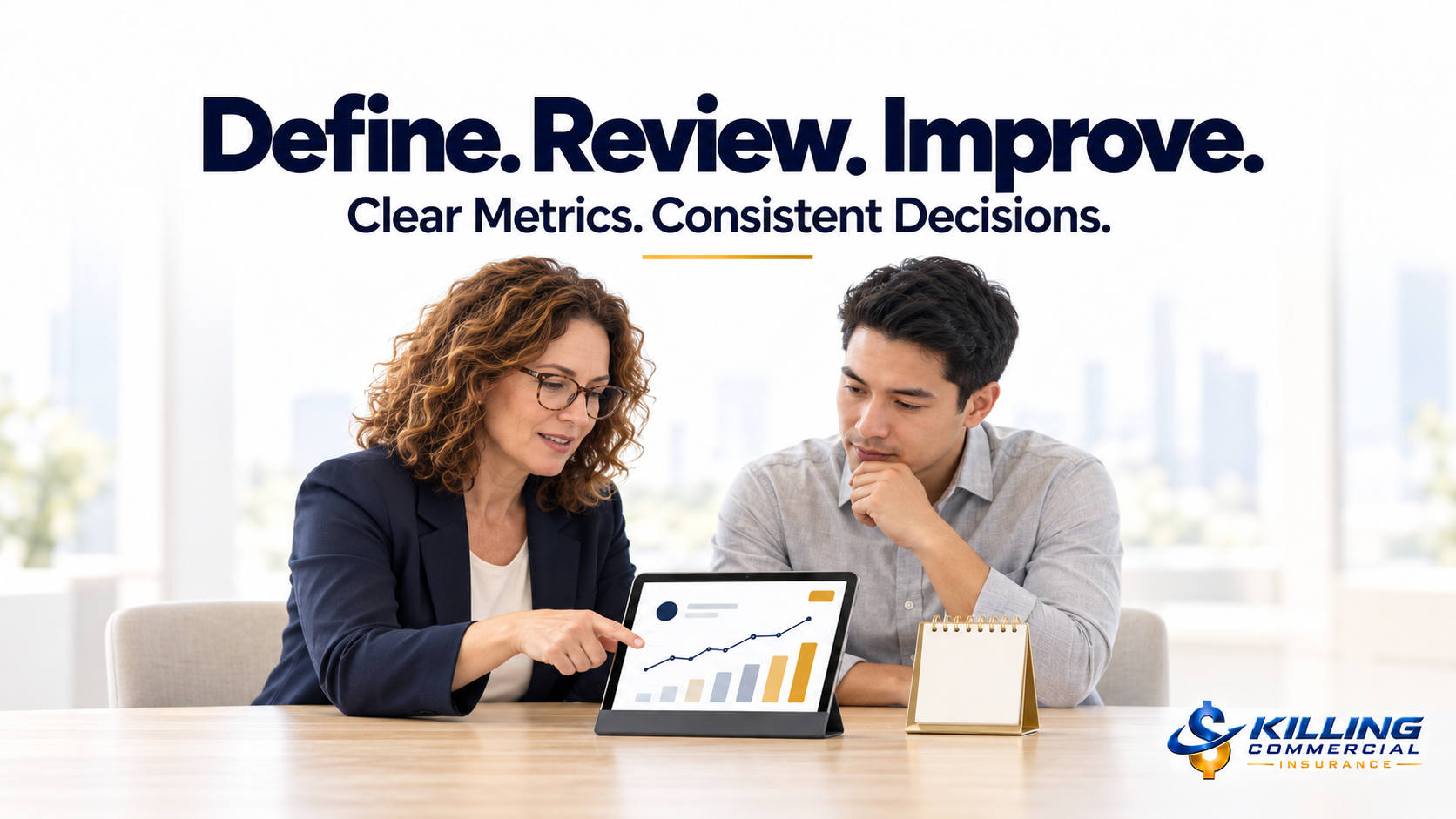 Agency owner and operations lead reviewing performance trends on a tablet beside a desk calendar.